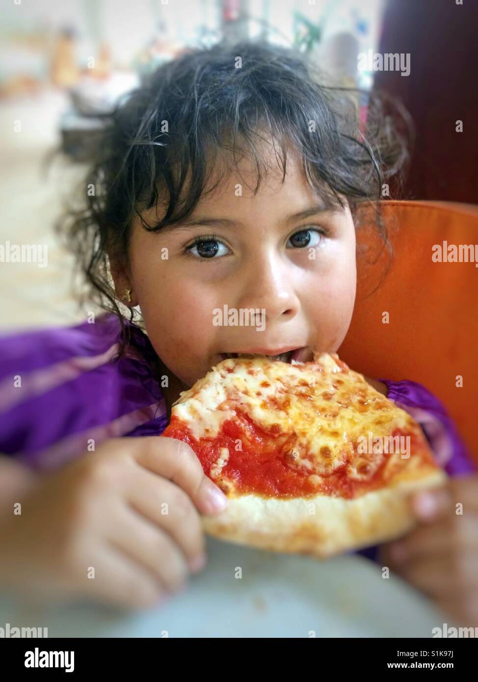 Little girl eating a pizza. Stock Photo