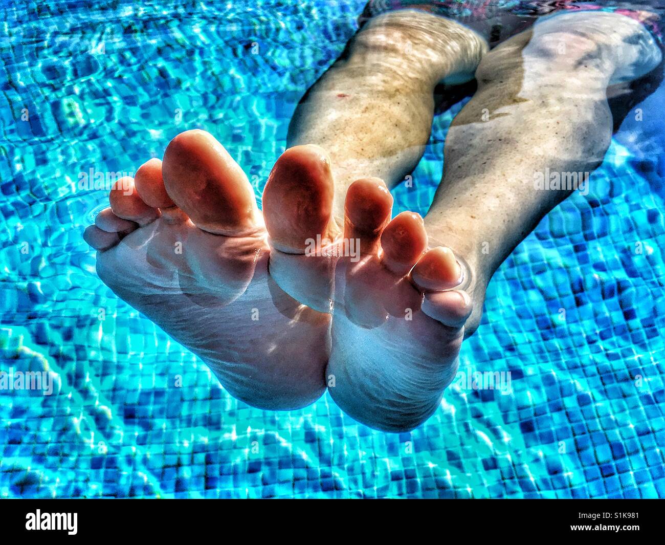 Woman  floating in swimming pool - Smartphone Captured Stock Image