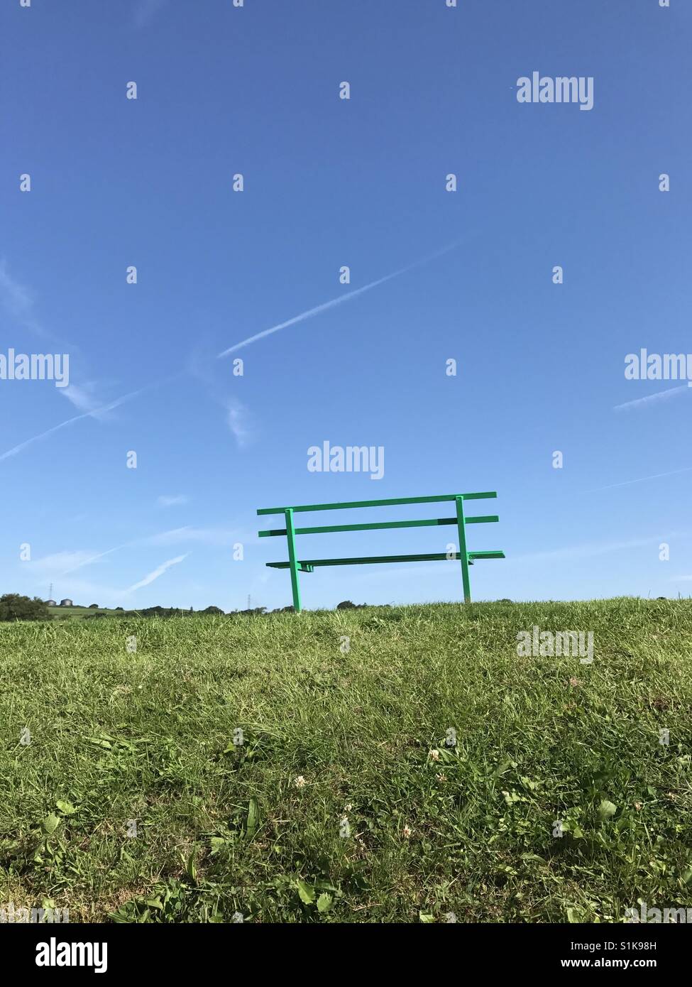 Empty seat in park against the blue sky of a summer's day (upright format view) Stock Photo