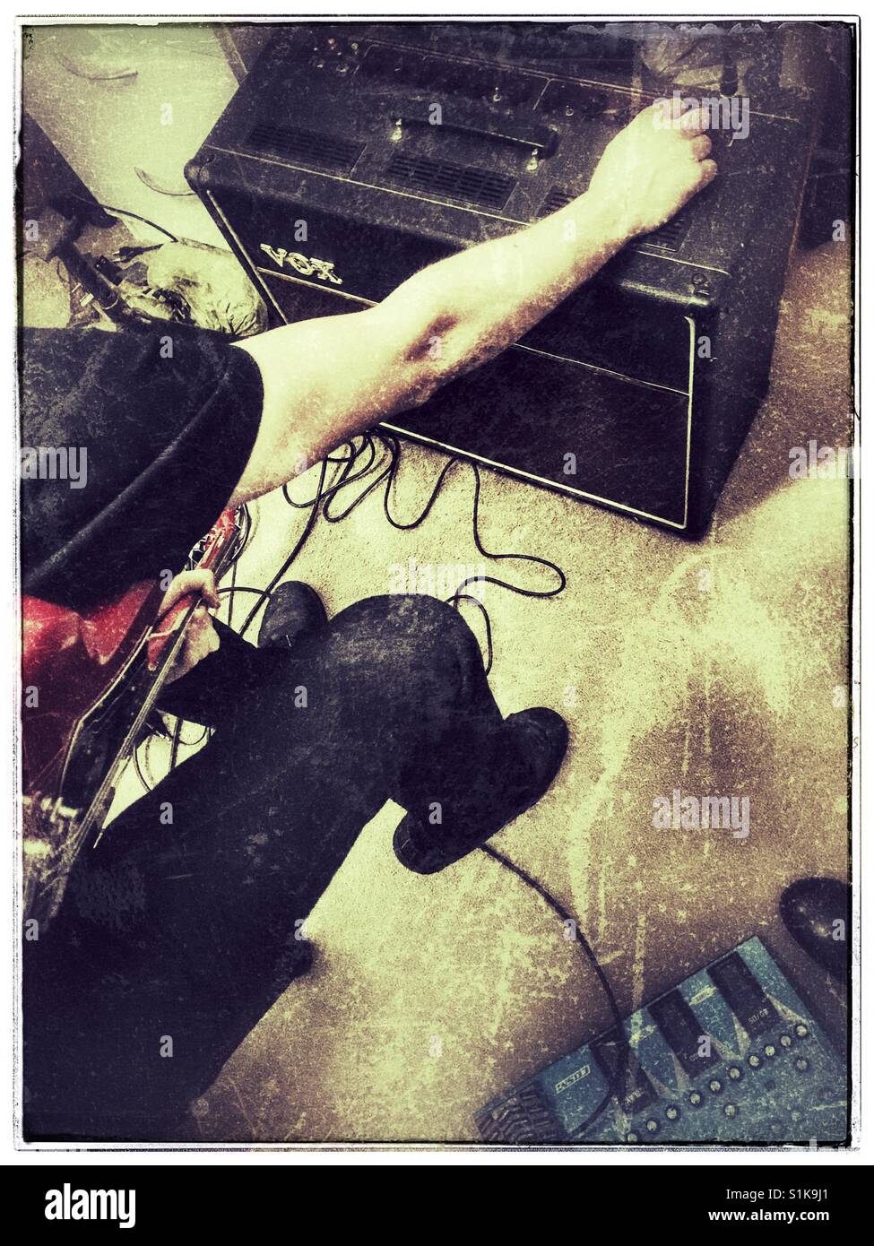 Musician adjusting his amplifier. - Smartphone Captured Stock Image