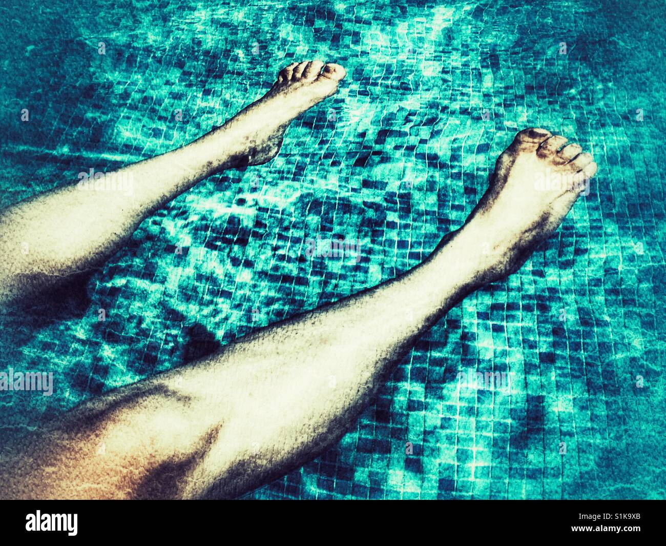 Keeping cool. Woman floating in a swimming pool. - Smartphone Captured Stock Image
