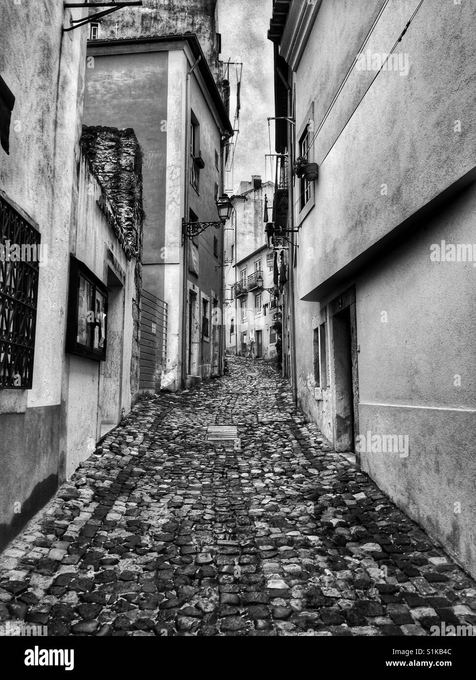 Black and white of narrow cobblestone street in Lisbon, Portugal. Stock Photo