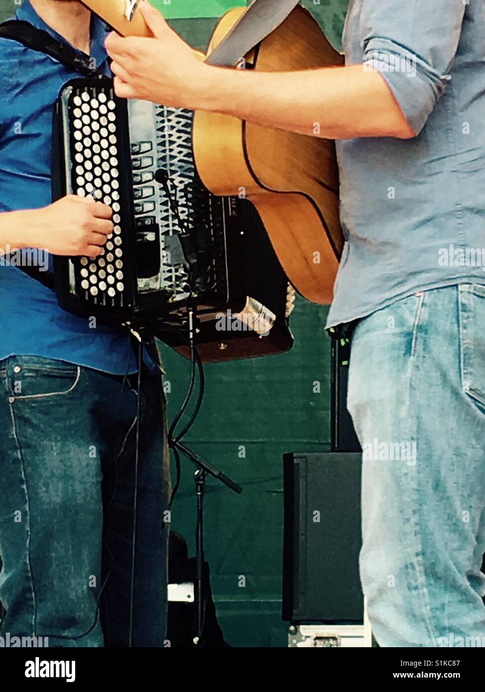 Two musicians jamming at festival with accordion and guitar London ...