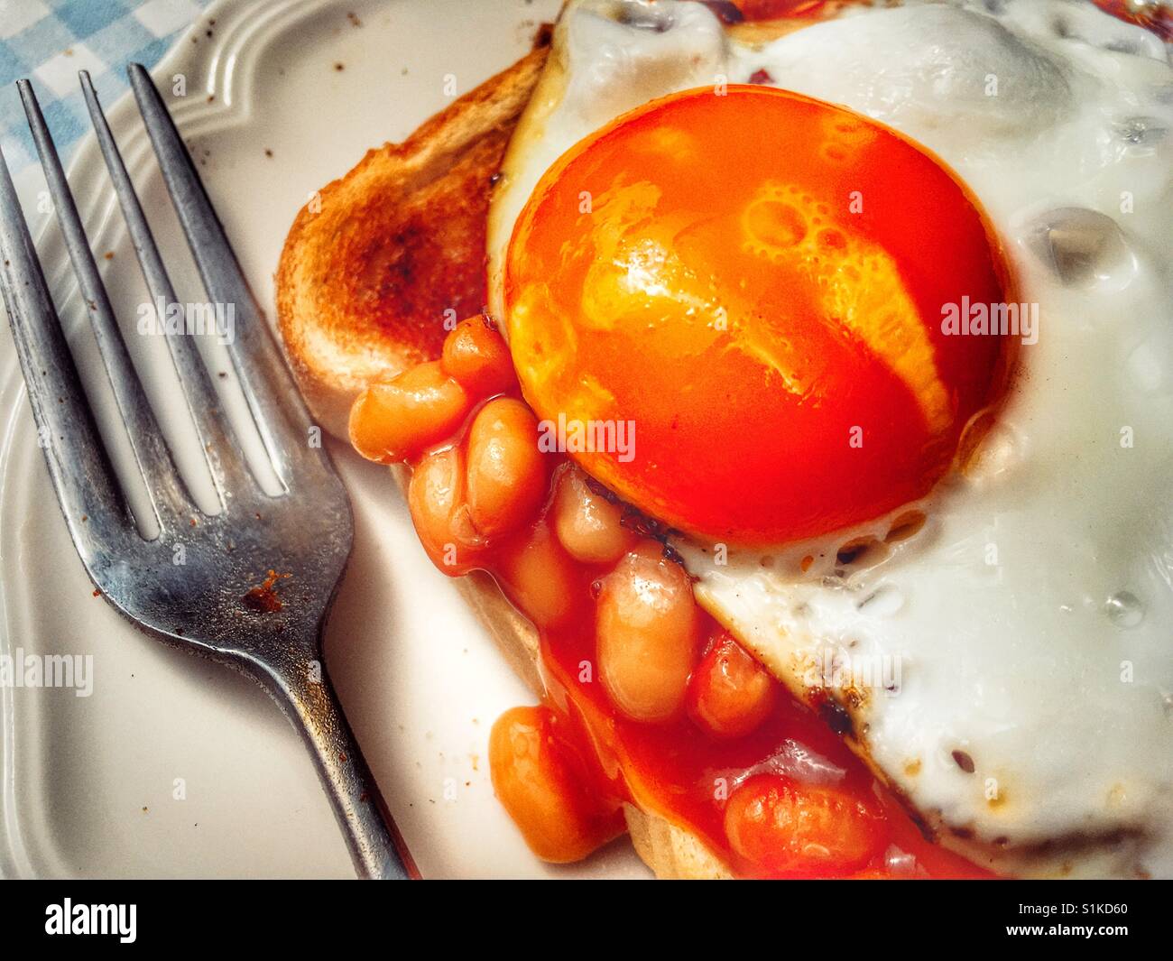 Baked beans on toast with fried egg Stock Photo