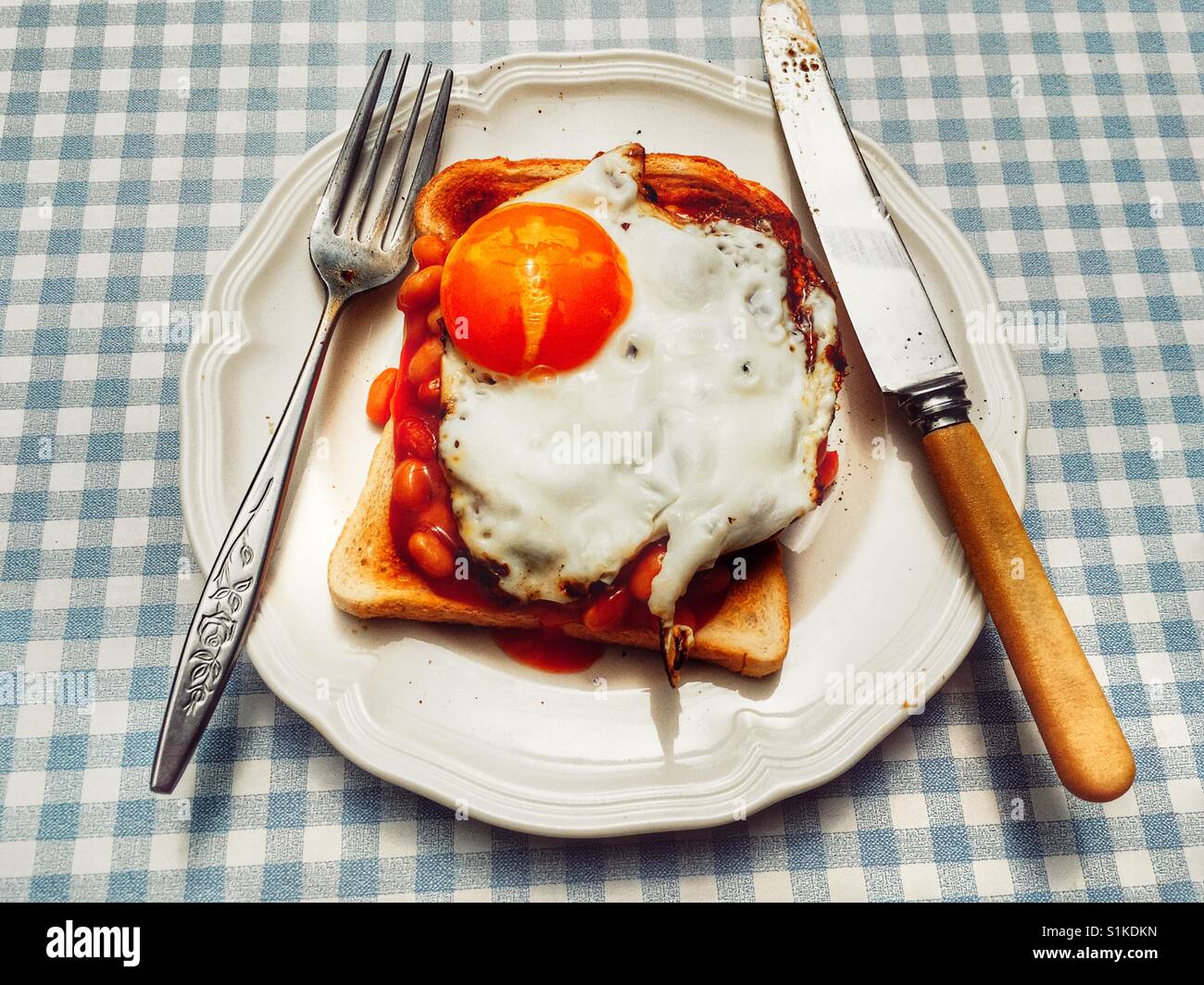 Baked beans and fried egg on toast Stock Photo