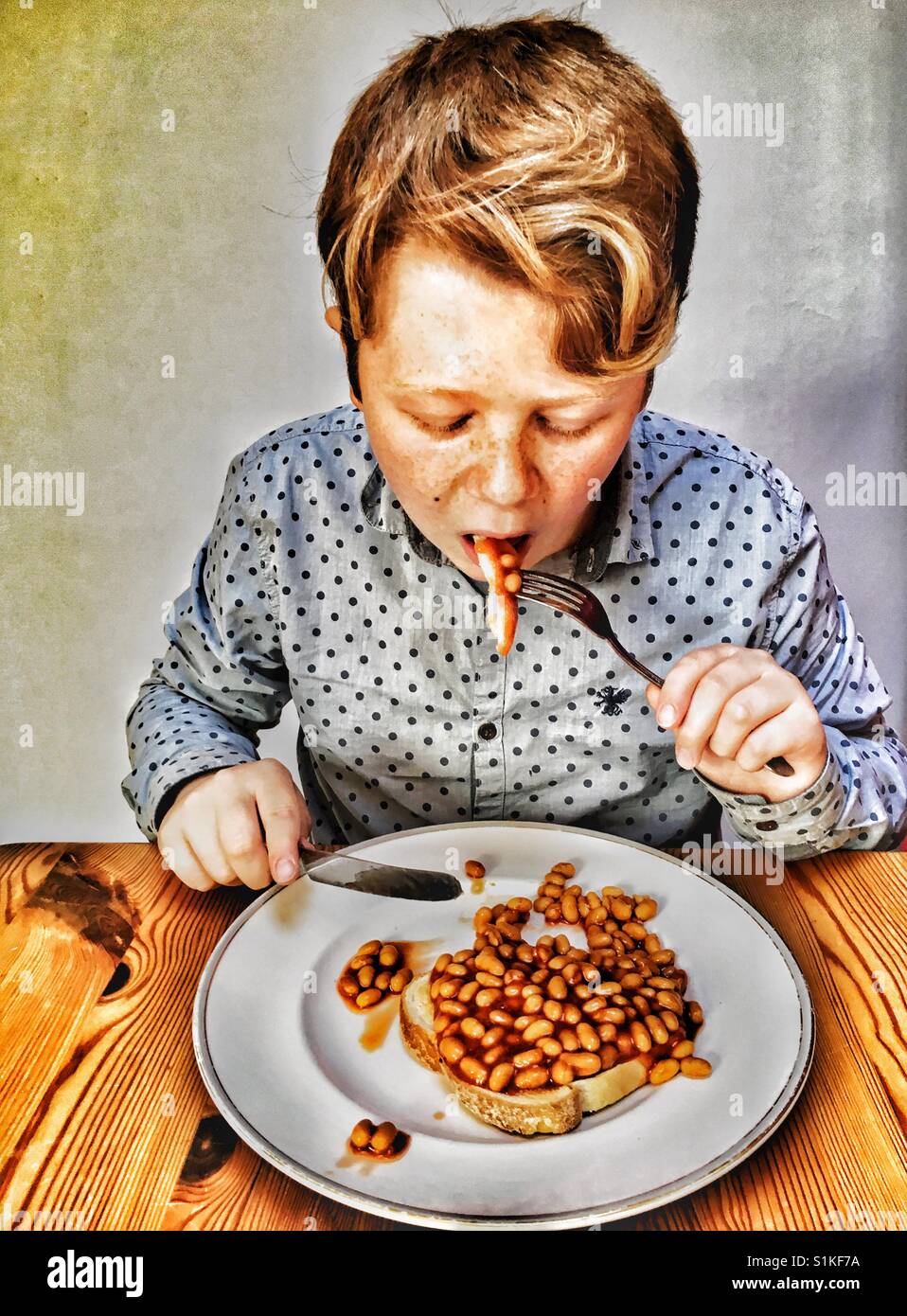 Boy eating baked beans on toast Stock Photo Alamy