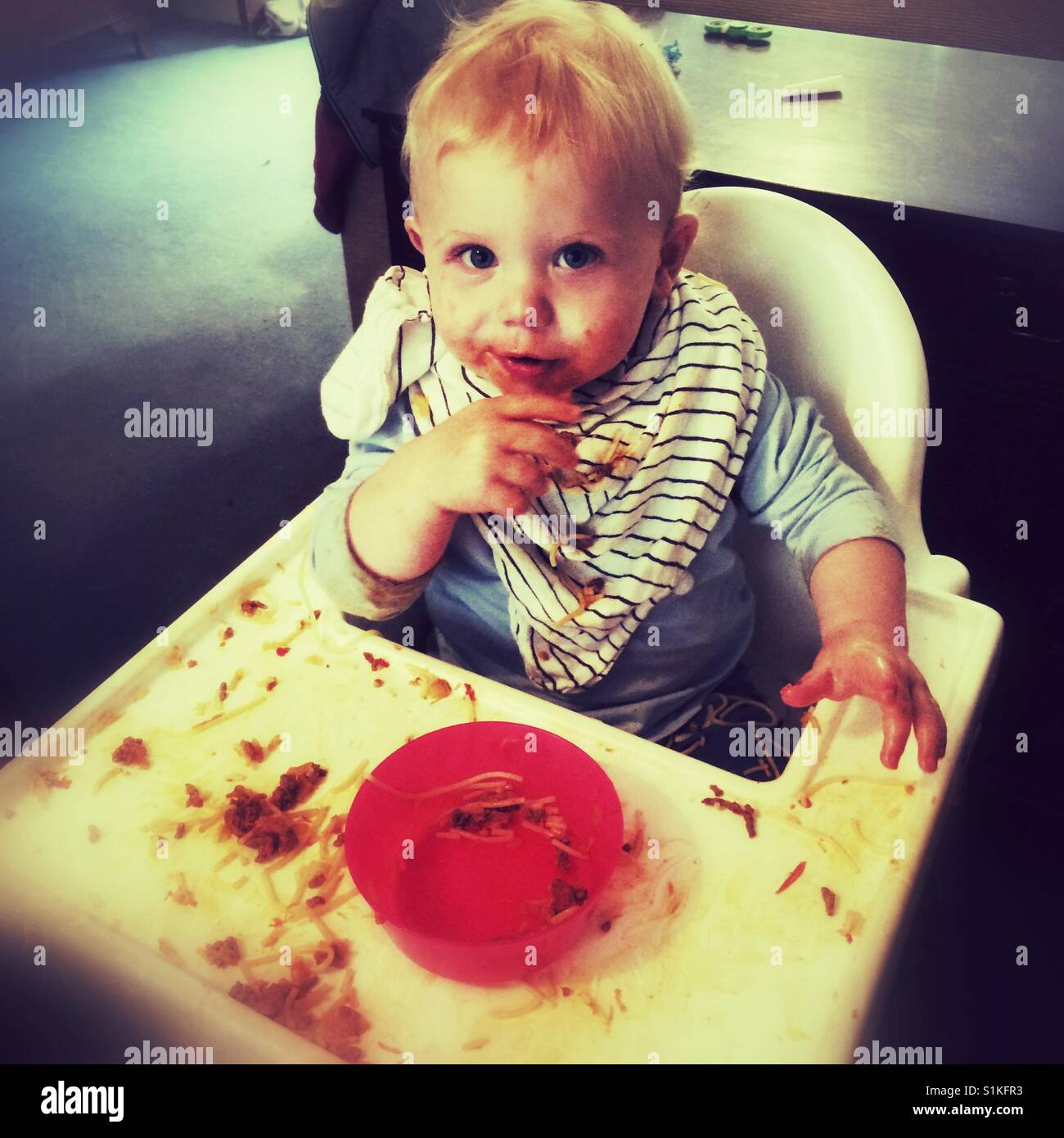 Eleven month old baby boy eating pasta - Smartphone Captured Stock Image