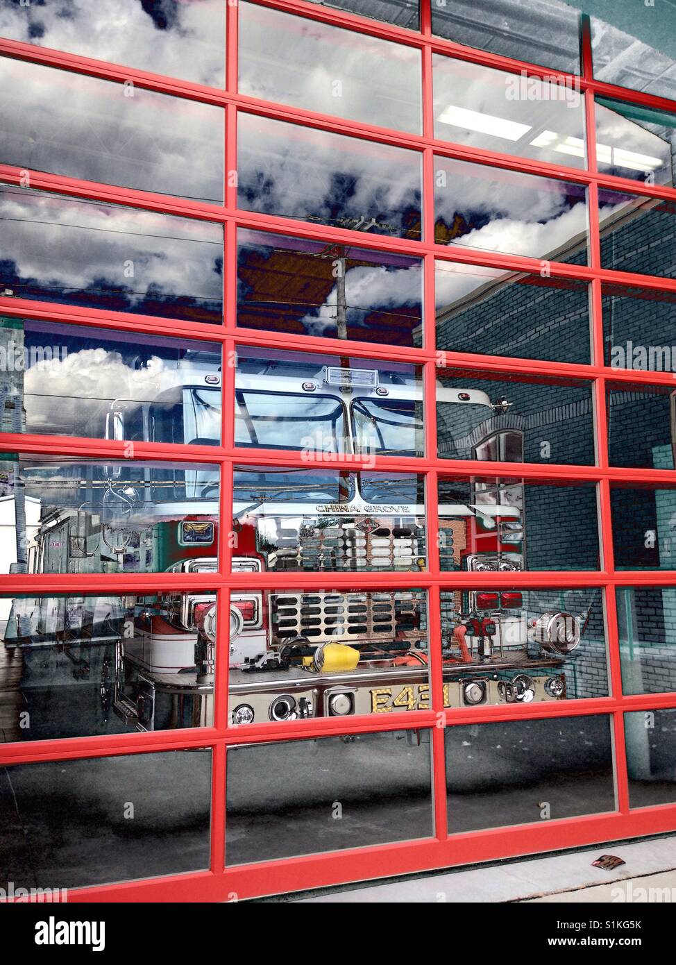 Red fire engine behind window reflecting clouds and blue sky- North Carolina - Smartphone Captured Stock Image