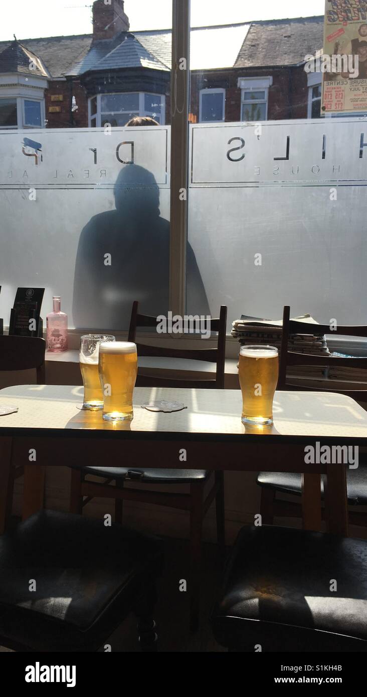 Pints in a pub with the sun shining through the window - Smartphone Captured Stock Image