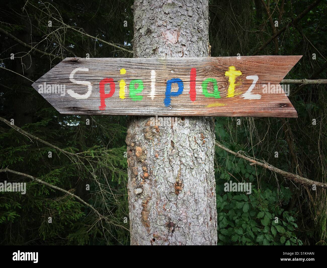 Colourful sign pointing to a playground in German Stock Photo