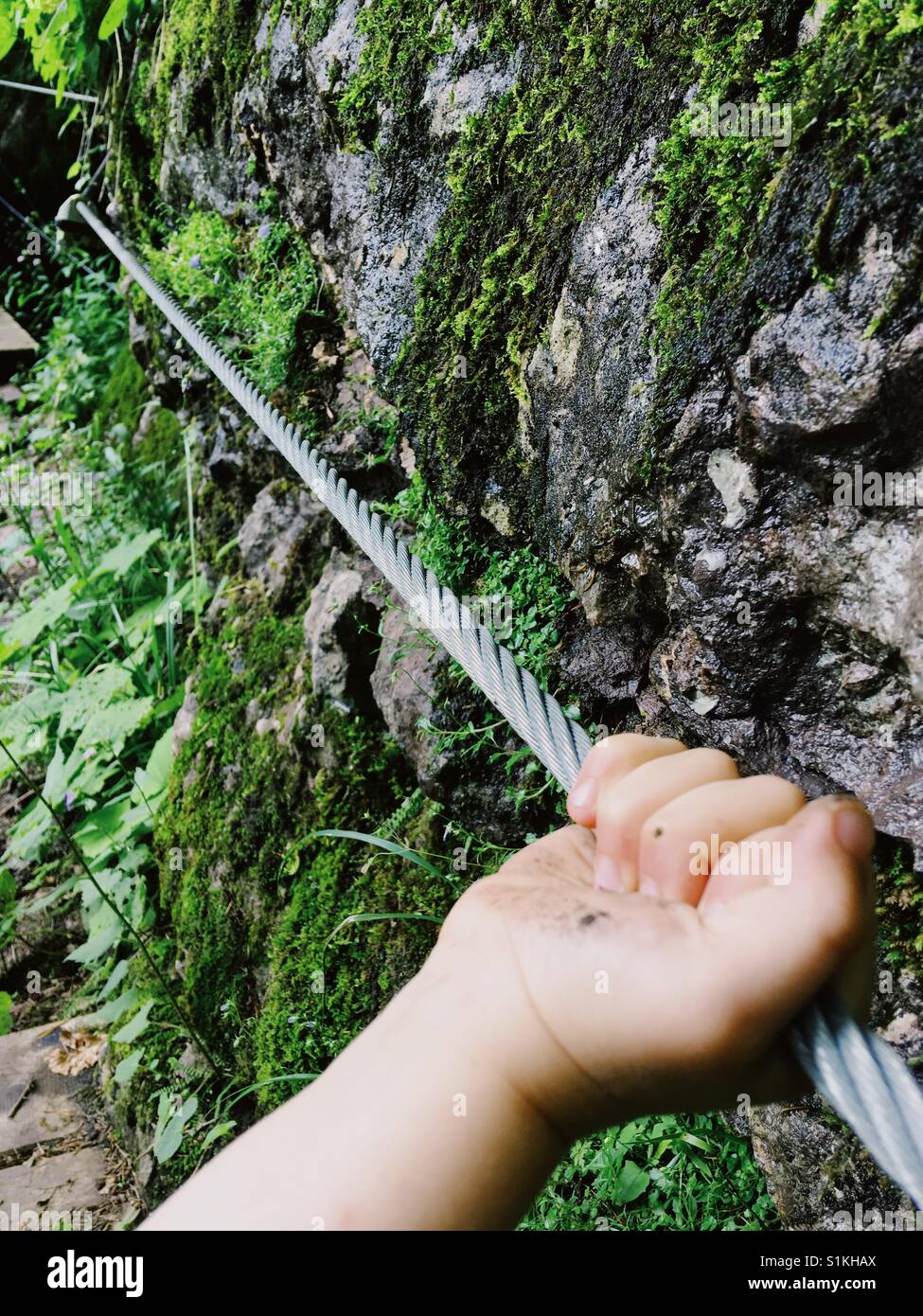 A Child's hand holding a steel cable - Smartphone Captured Stock Image