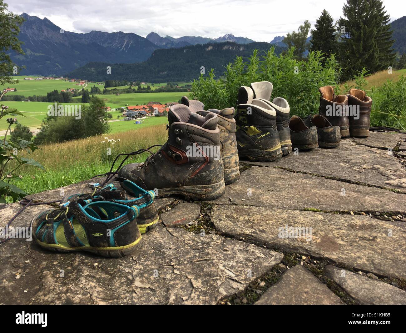 Shoes in a row with a meadow and Mountains in the background - Smartphone Captured Stock Image