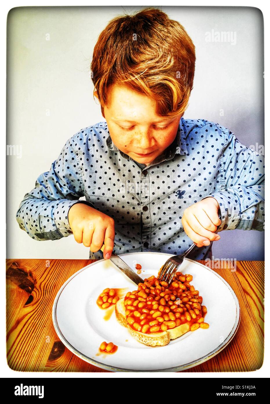 11year old boy eating baked beans on toast Stock Photo Alamy