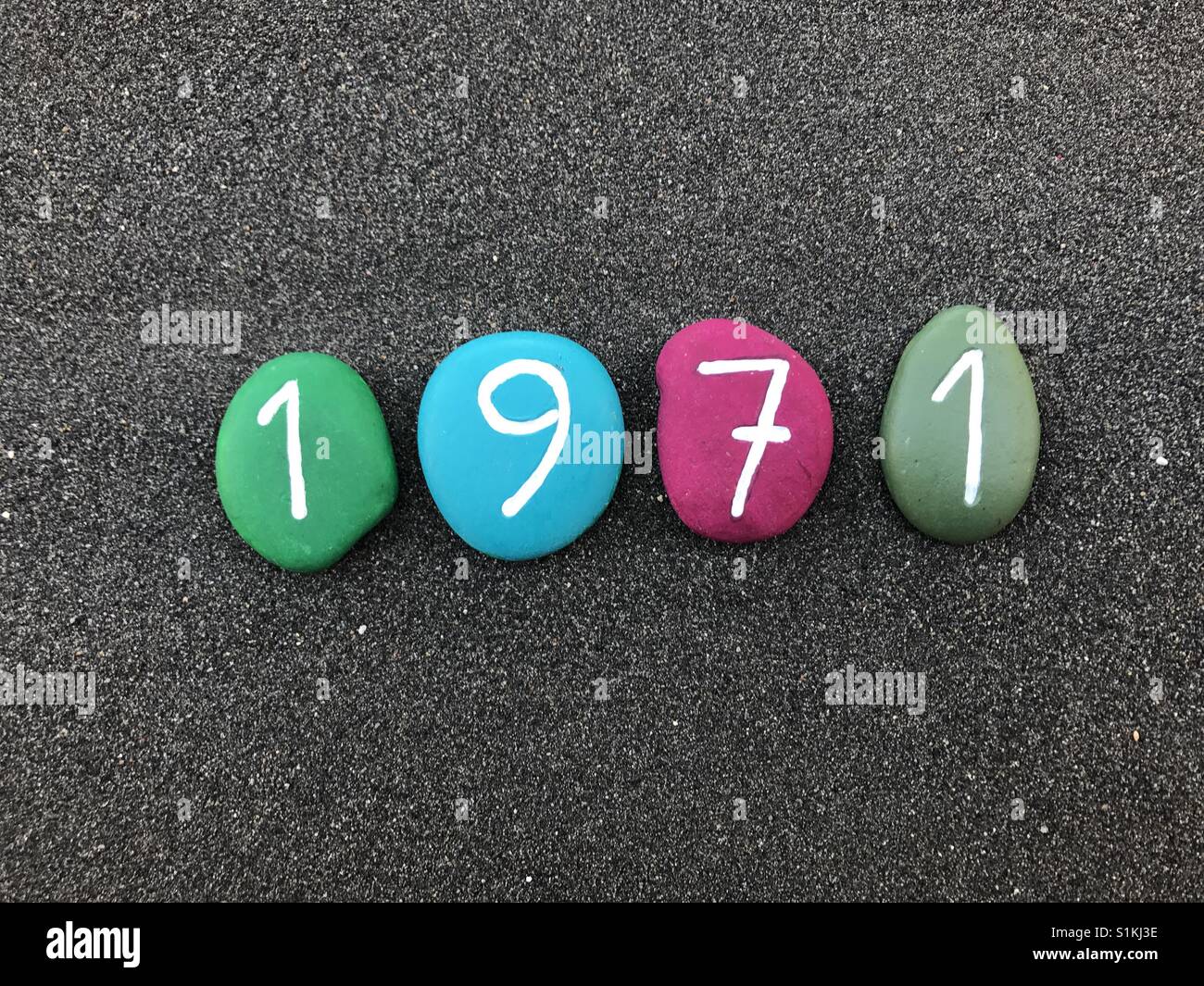 1971 year with colored stones over black volcanic sand - Smartphone Captured Stock Image