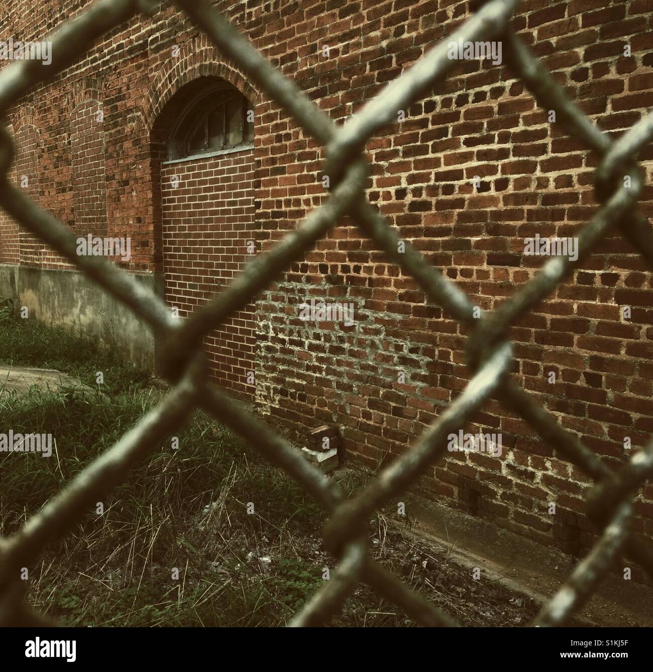 Brick wall behind rusty chain link fence- North Carolina - Smartphone Captured Stock Image