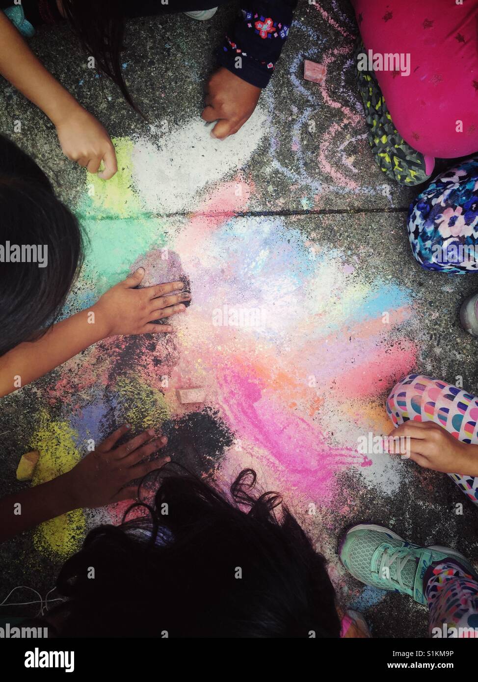Children coloring pavement with chalk Stock Photo