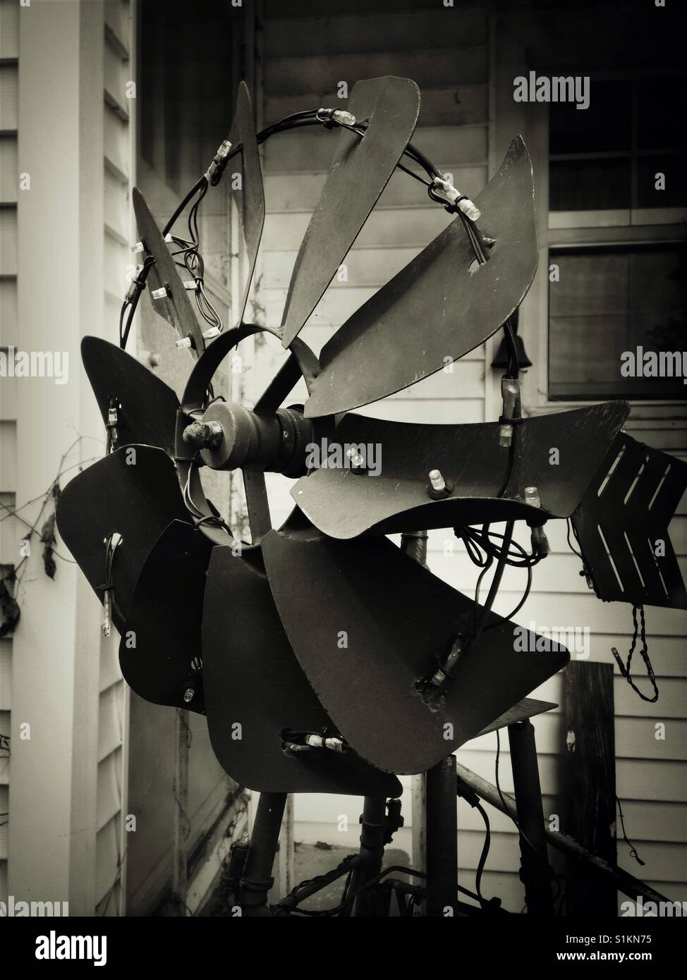 Windmill yard decor with lights in front of back doorway and window of old White House - Smartphone Captured Stock Image