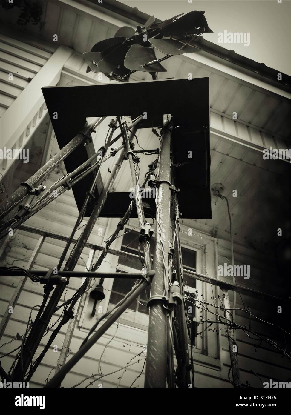 Upward view of yard art windmill in front of back doorway of White House - Smartphone Captured Stock Image
