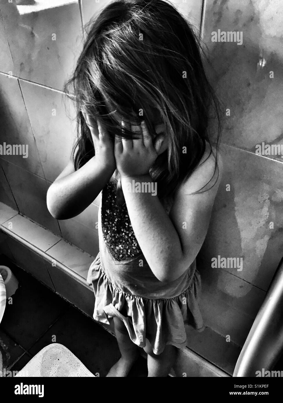 Crying girl in bathroom. Stock Photo