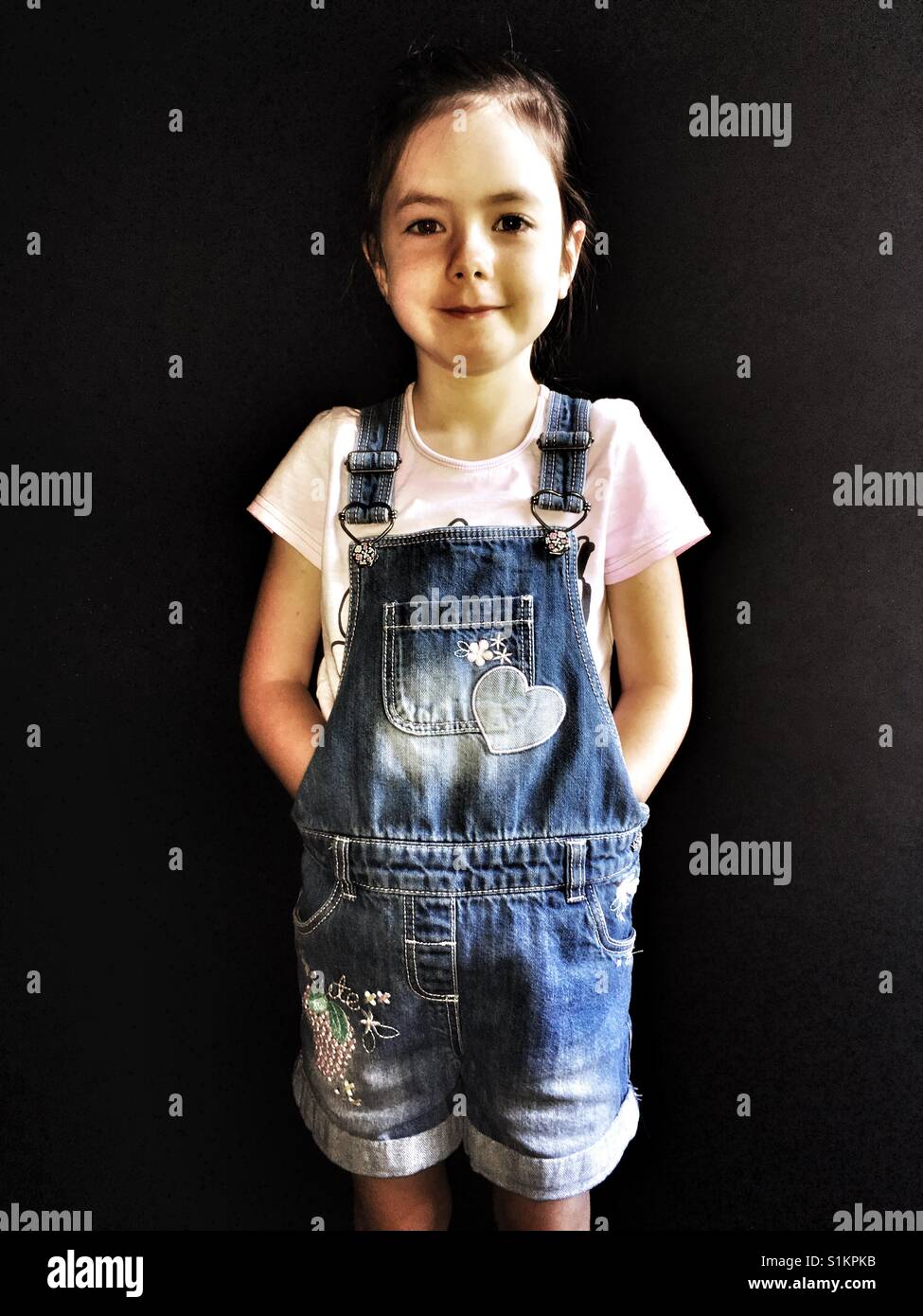 Girl wearing denim dungarees Stock Photo Alamy