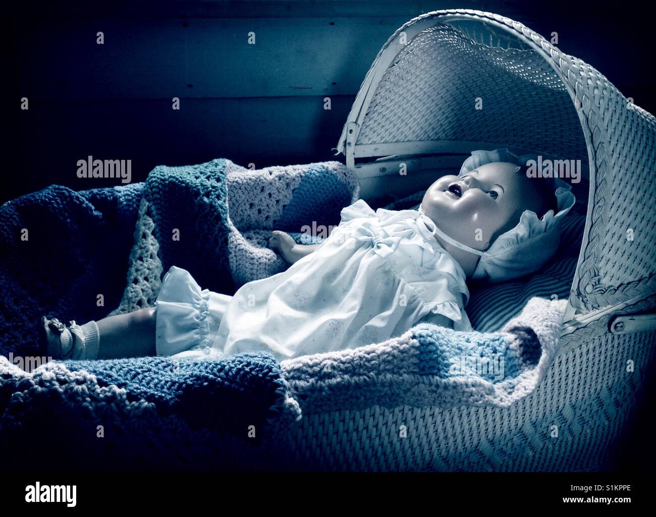 Nap time- Wearing a ruffled bonnet and dress, Doris the composition doll is down to nap in vintage bassinet - Smartphone Captured Stock Image