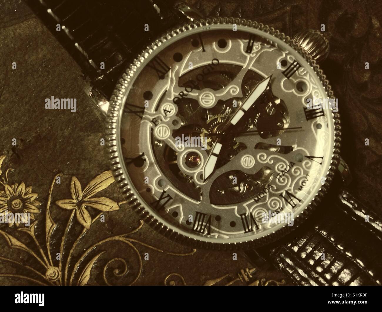 Visible movements in wristwatch, ornate leather Bible - Smartphone Captured Stock Image