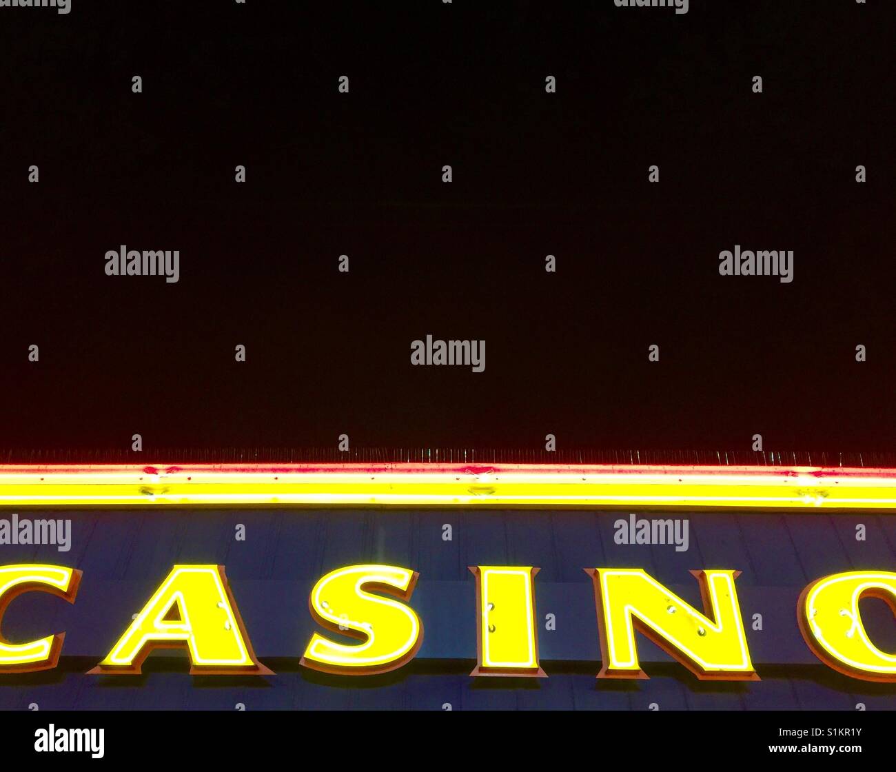 Illuminated casino sign at night against a black sky - Smartphone Captured Stock Image