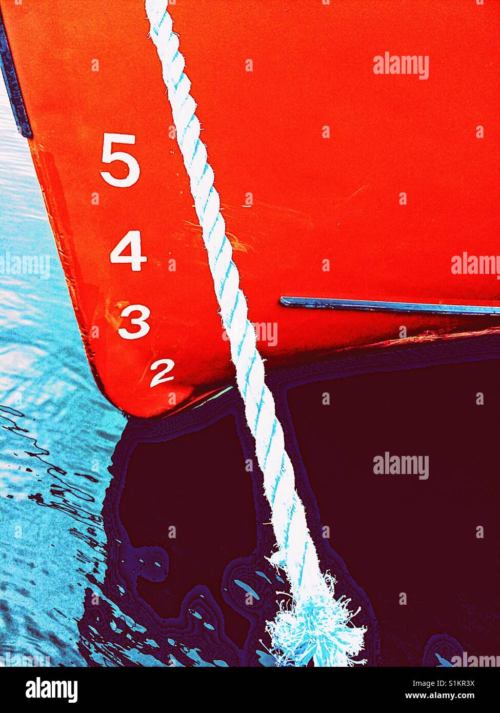 Ship's draft on red hull of moored ship. The vertical distance between the waterline and the bottom of the hull. - Smartphone Captured Stock Image