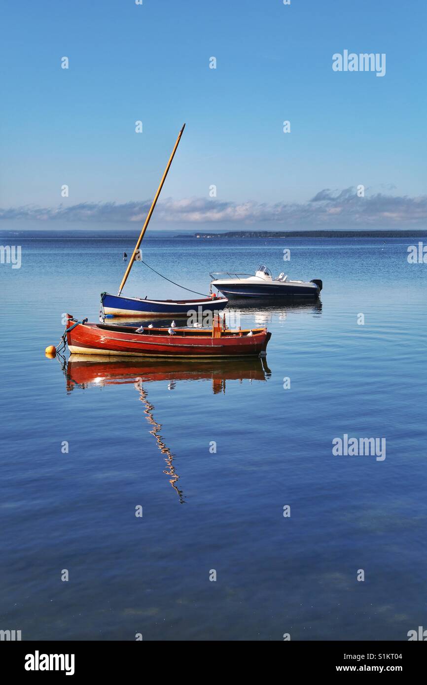 Three boats mirrored in water Stock Photo