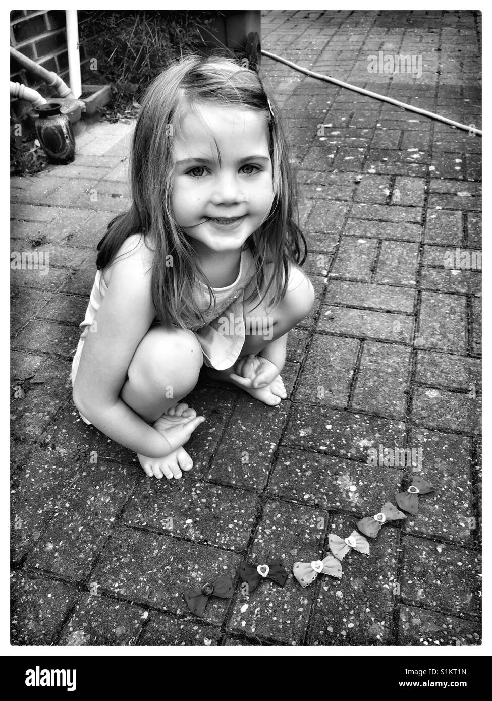 Girl playing with hair bows outside. Stock Photo