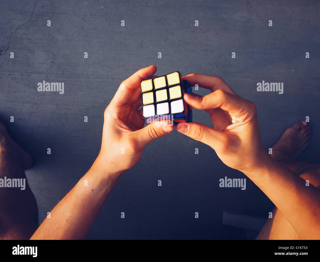 Point of view shot of a Rubik's Cube being solved a young man. Stock Photo