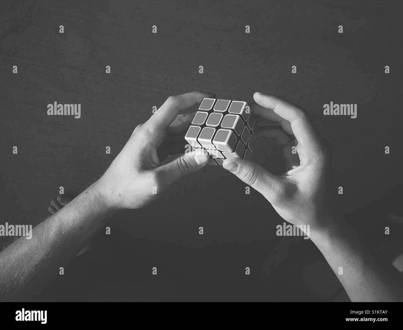 Hands holding a speed cube. In black and white. - Smartphone Captured Stock Image