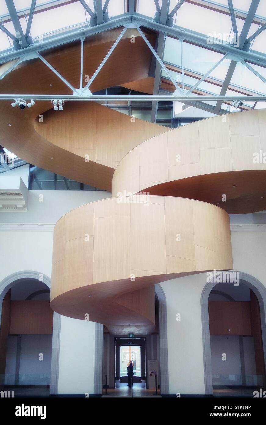 Baroque Stair, Frank Gehry AGO A.G.O. Art Gallery of Ontario interior, Toronto Ontario Canada. A figure is silhouetted in the doorway. - Smartphone Captured Stock Image