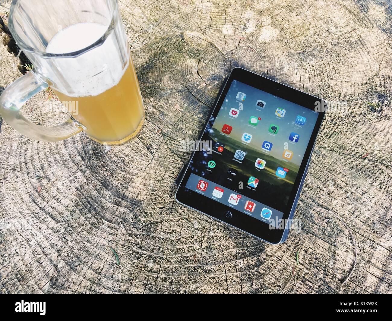 A tablet and a beer on a tree stump - Smartphone Captured Stock Image