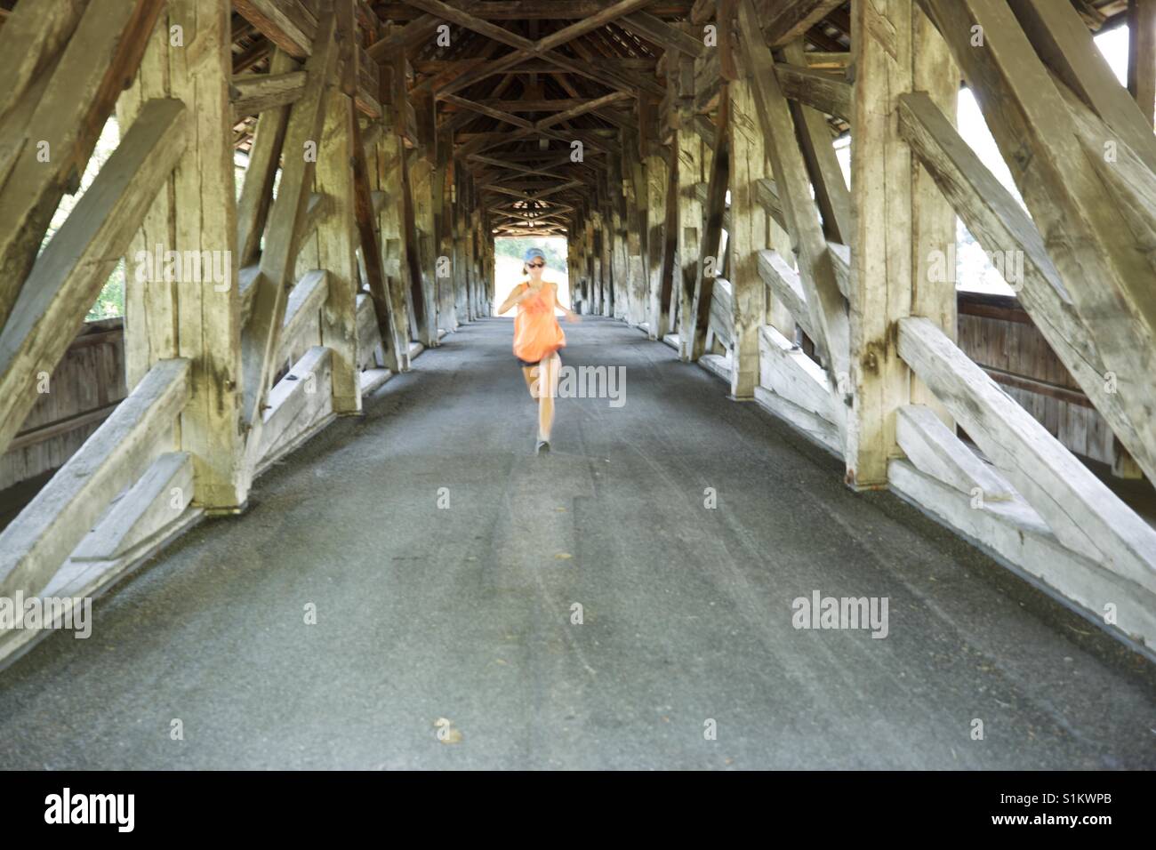 Teenage girl running across covered bridge Switzerland Stock Photo Alamy
