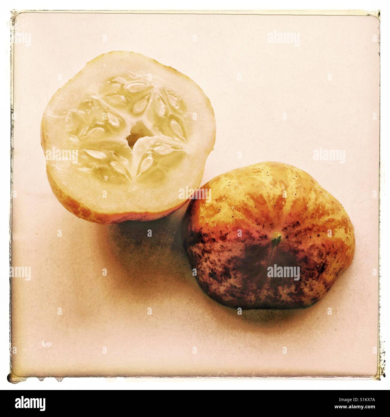 A lemon cucumber cut in half to show seeds and skin. - Smartphone Captured Stock Image