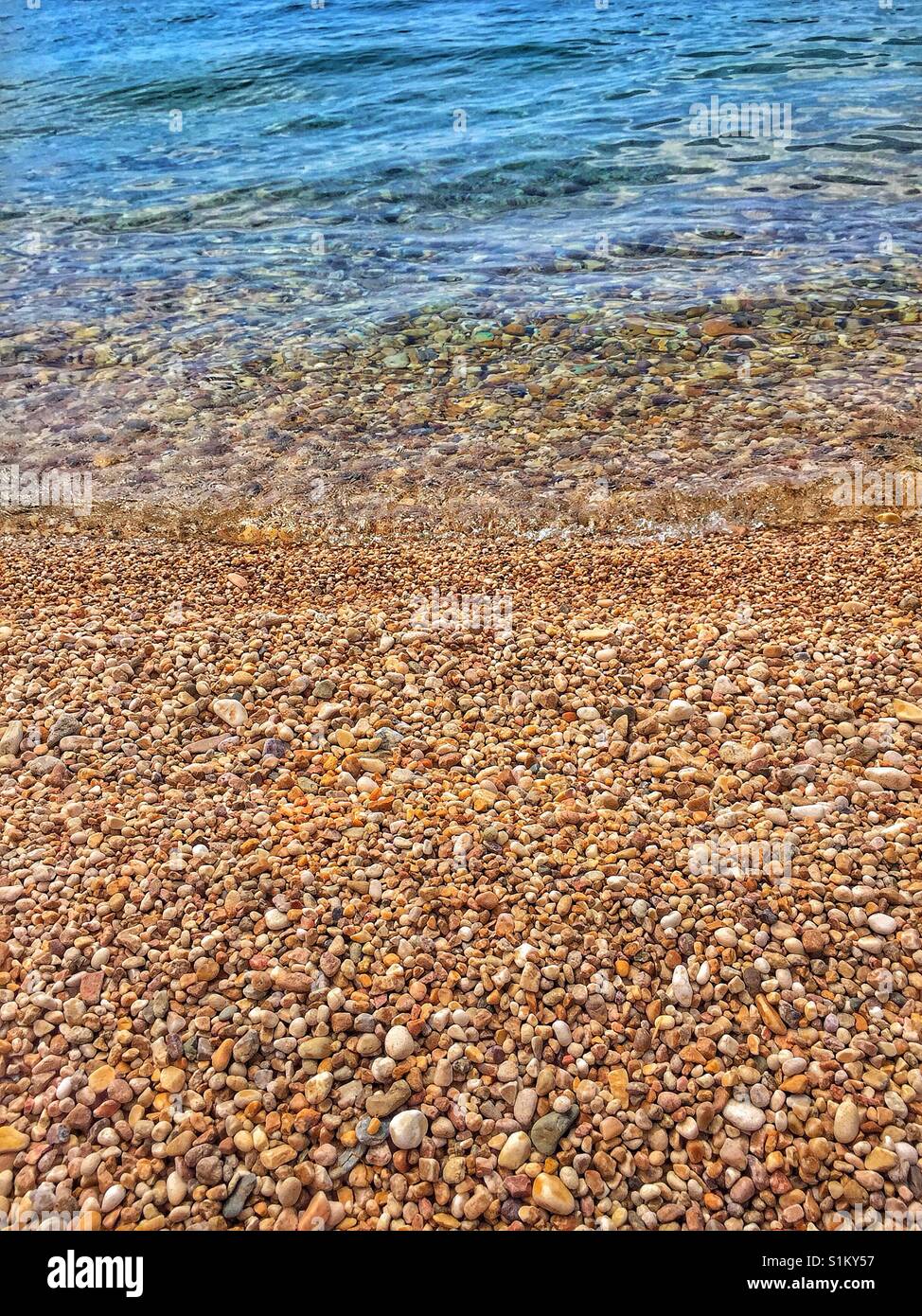 Pebble beach and gentle wave. Peaceful calm scene. Suitable for a background. Stock Photo