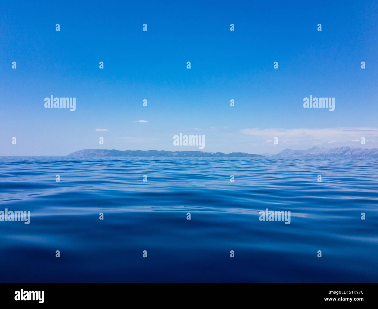 Empty blue sea and island at background Stock Photo