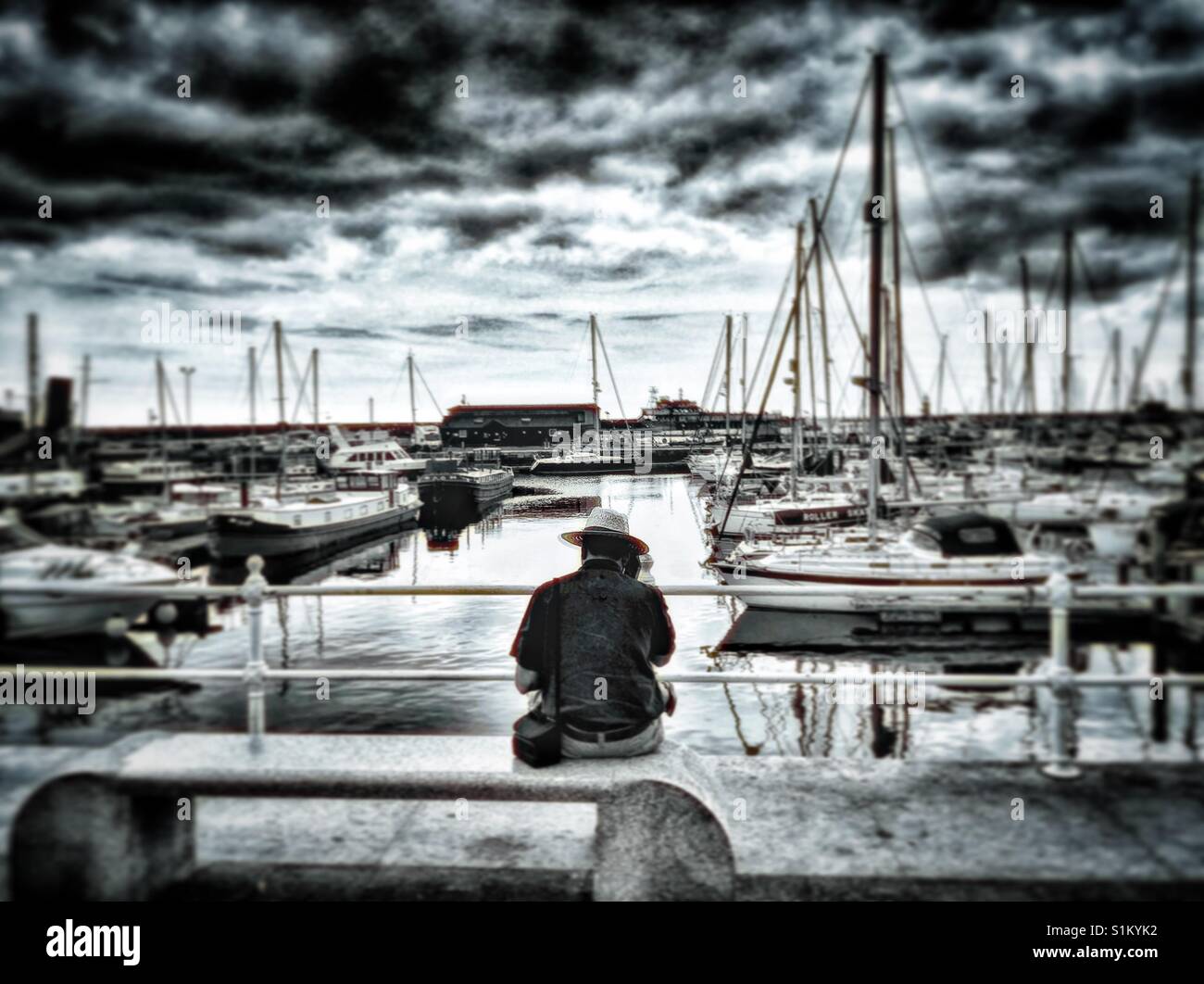 A man sitting on a bench at the marina in Ramsgate. - Smartphone Captured Stock Image