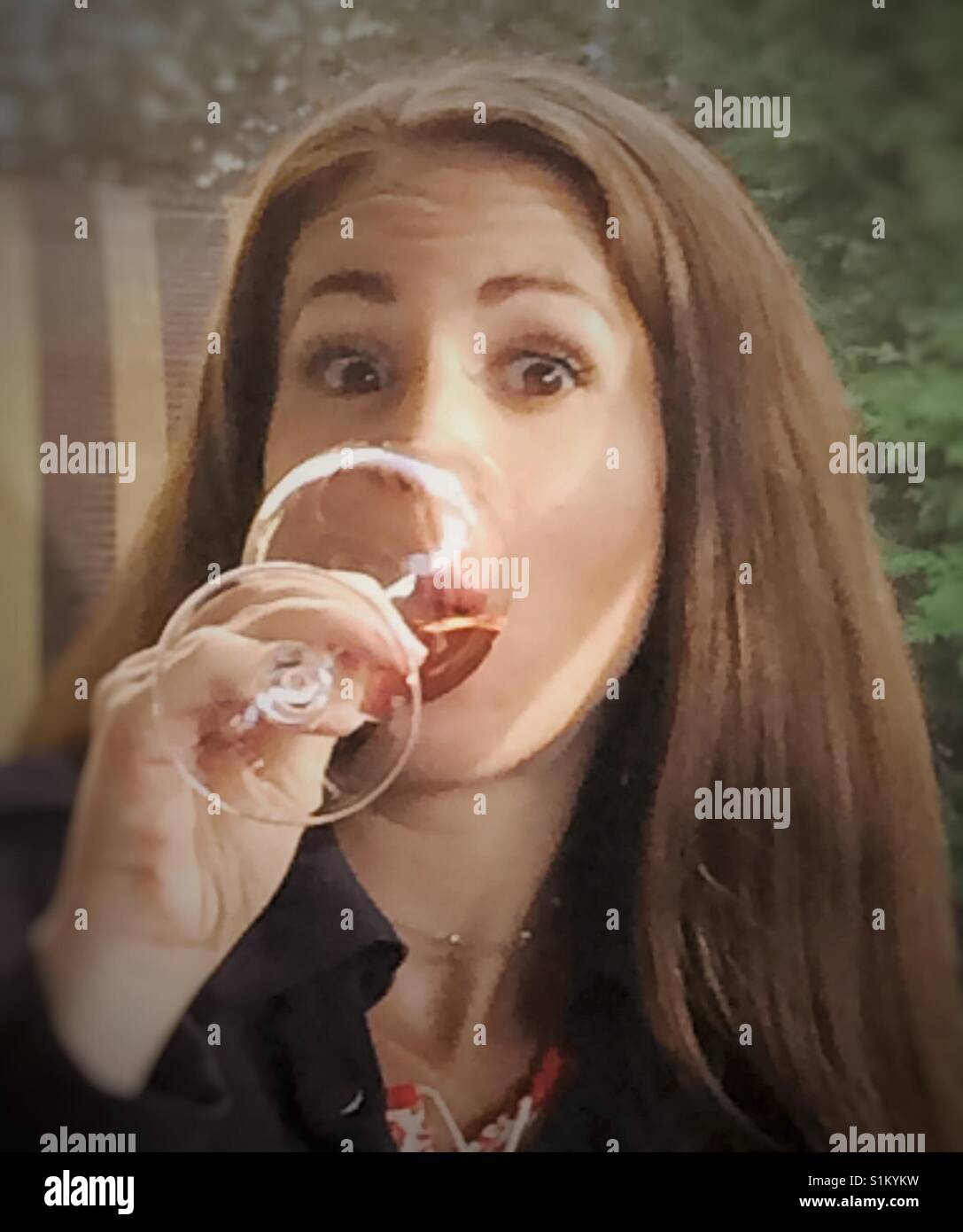 Woman drinking wine on a patio. Stock Photo