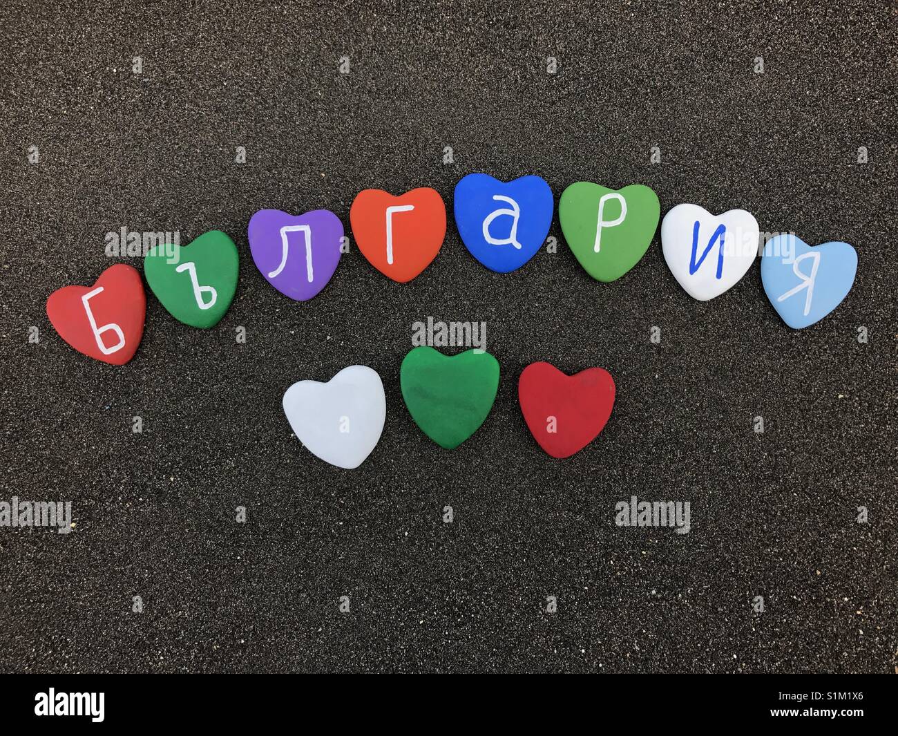 България, Bulgaria with colored heart stones over black volcanic sand - Smartphone Captured Stock Image