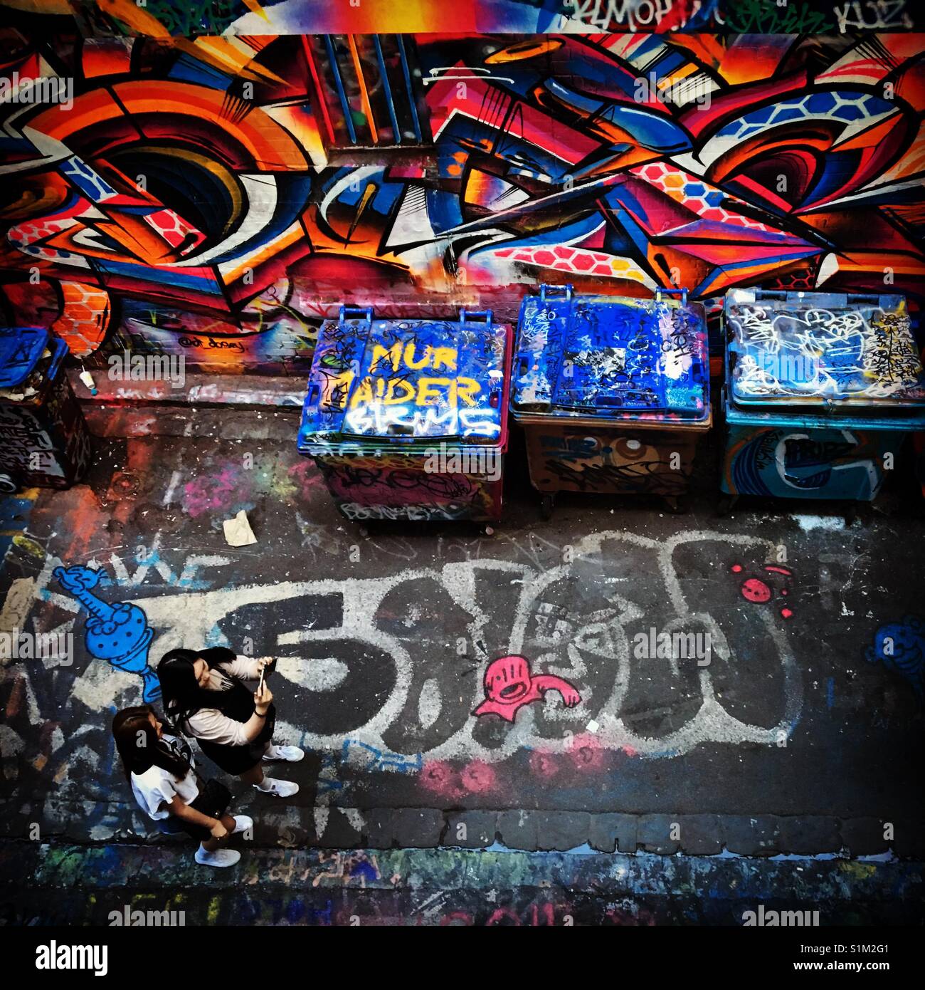 Melbourne's Hosier Lane with girls taking photos of graffiti - Smartphone Captured Stock Image