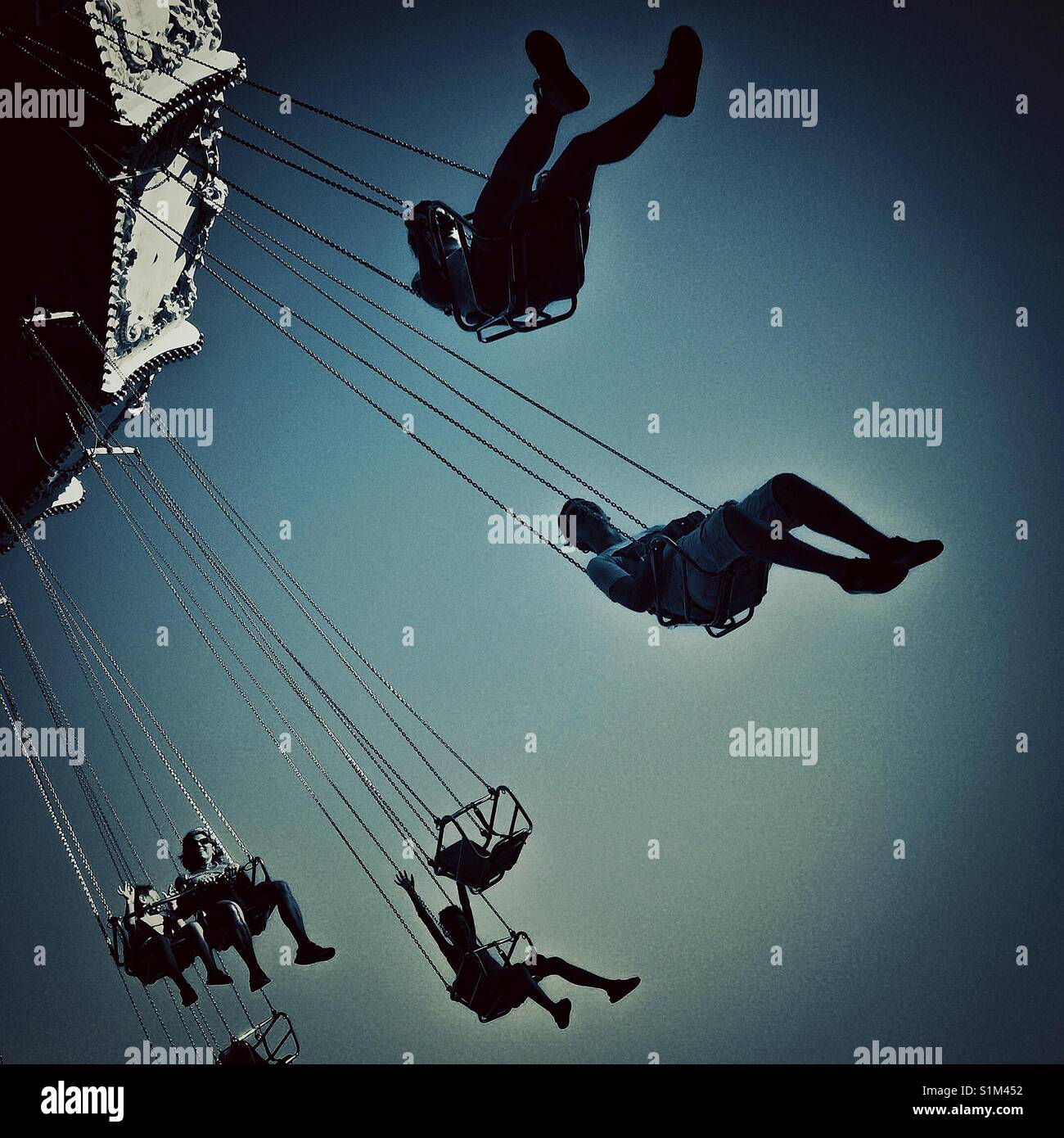 People enjoying on a swing carousel. Tibidabo of Barcelona fairground - Smartphone Captured Stock Image