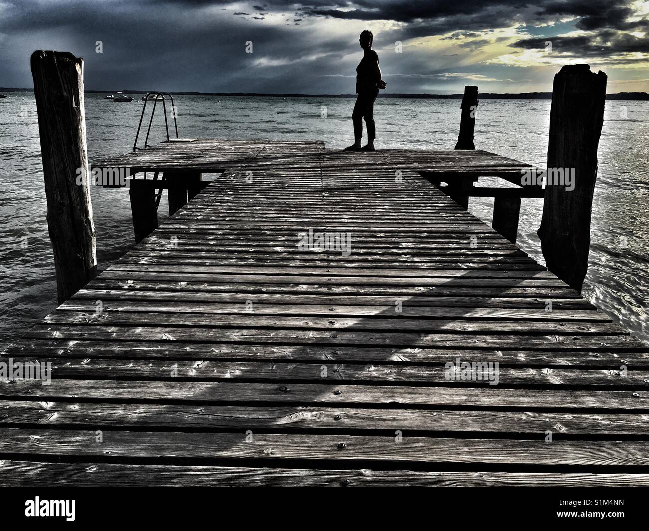 Woman standing on jetty pier in evening - Smartphone Captured Stock Image