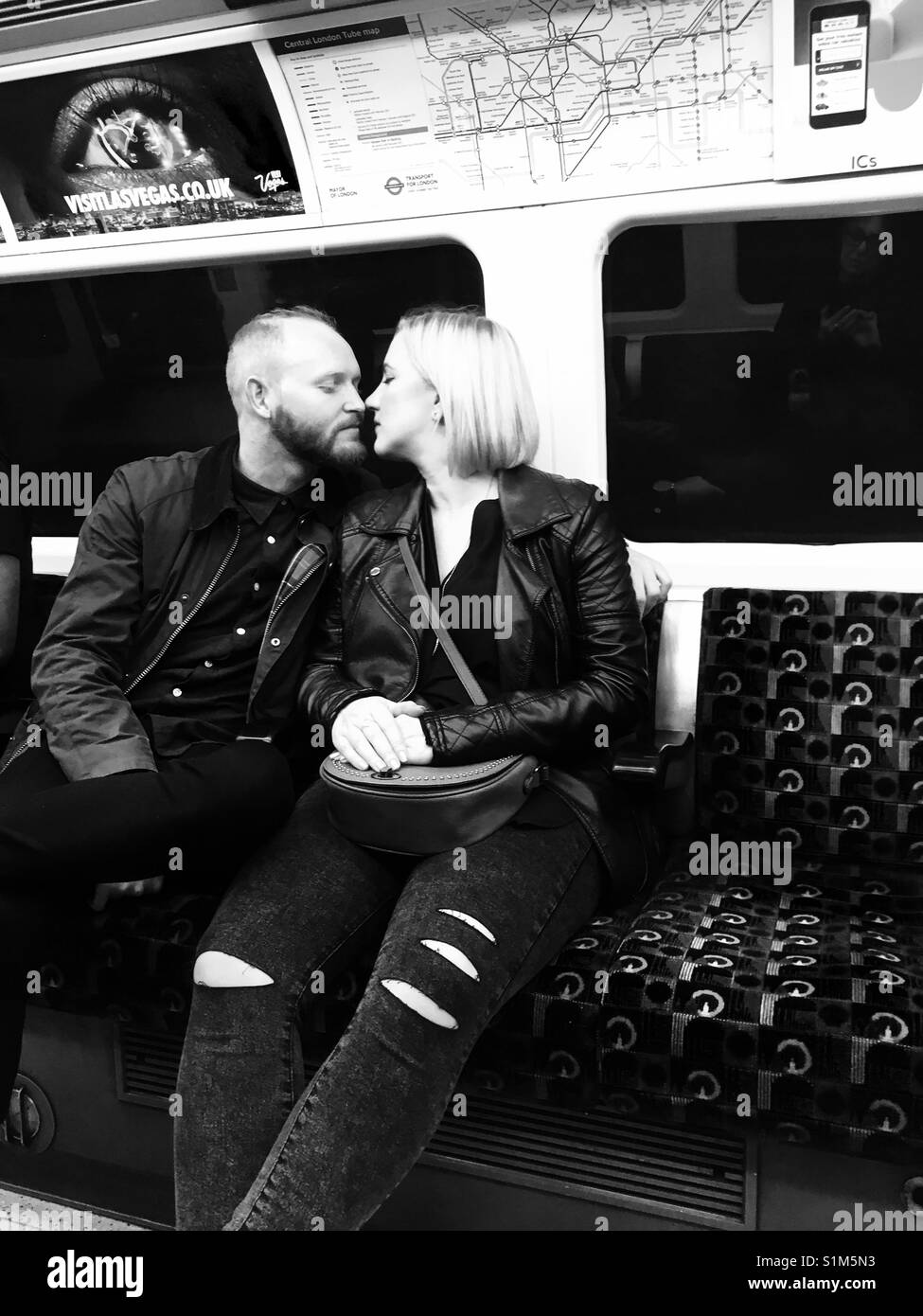 Young couple about to kiss on London Underground wearing jeans B& W photo Stock Photo