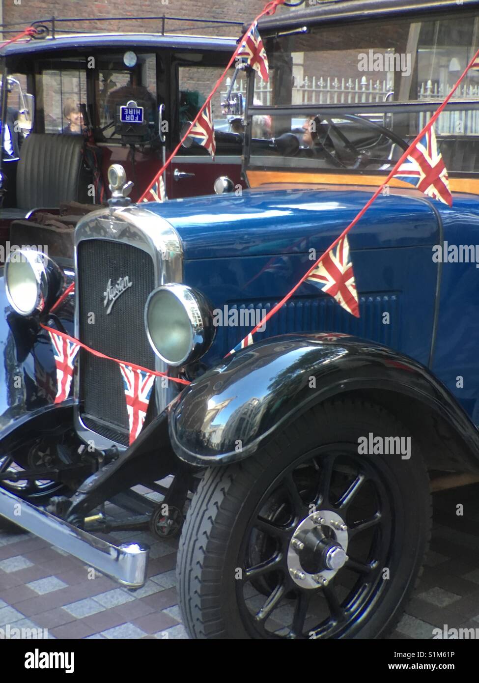 Antique Austin car at Costermongers annual festival decorated with bunting of British flag in London Stock Photo