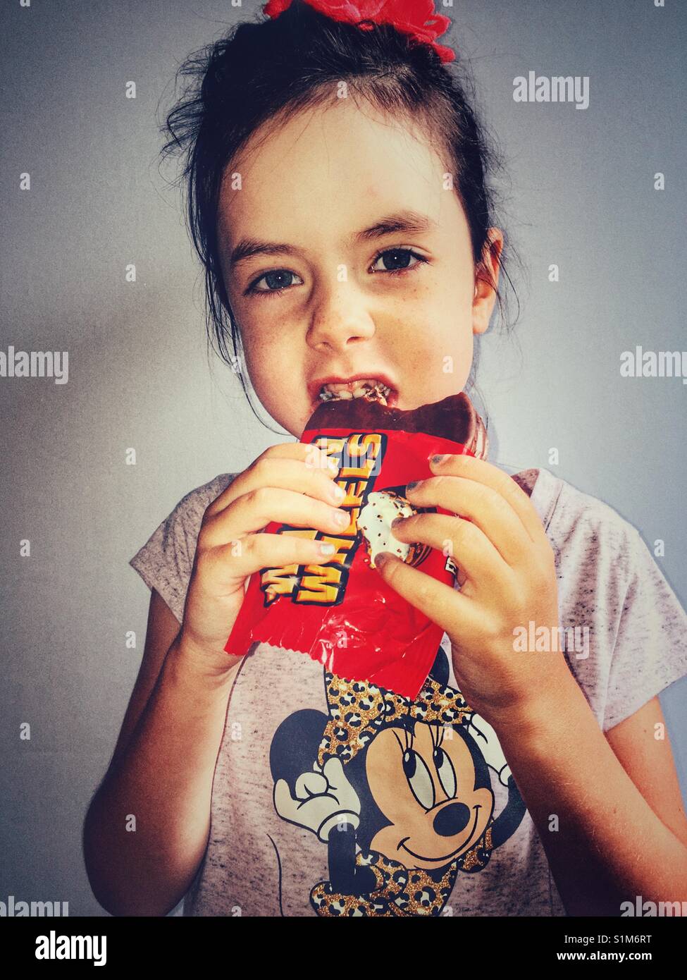 Girl eating wagon wheels chocolate biscuit hires stock photography and
