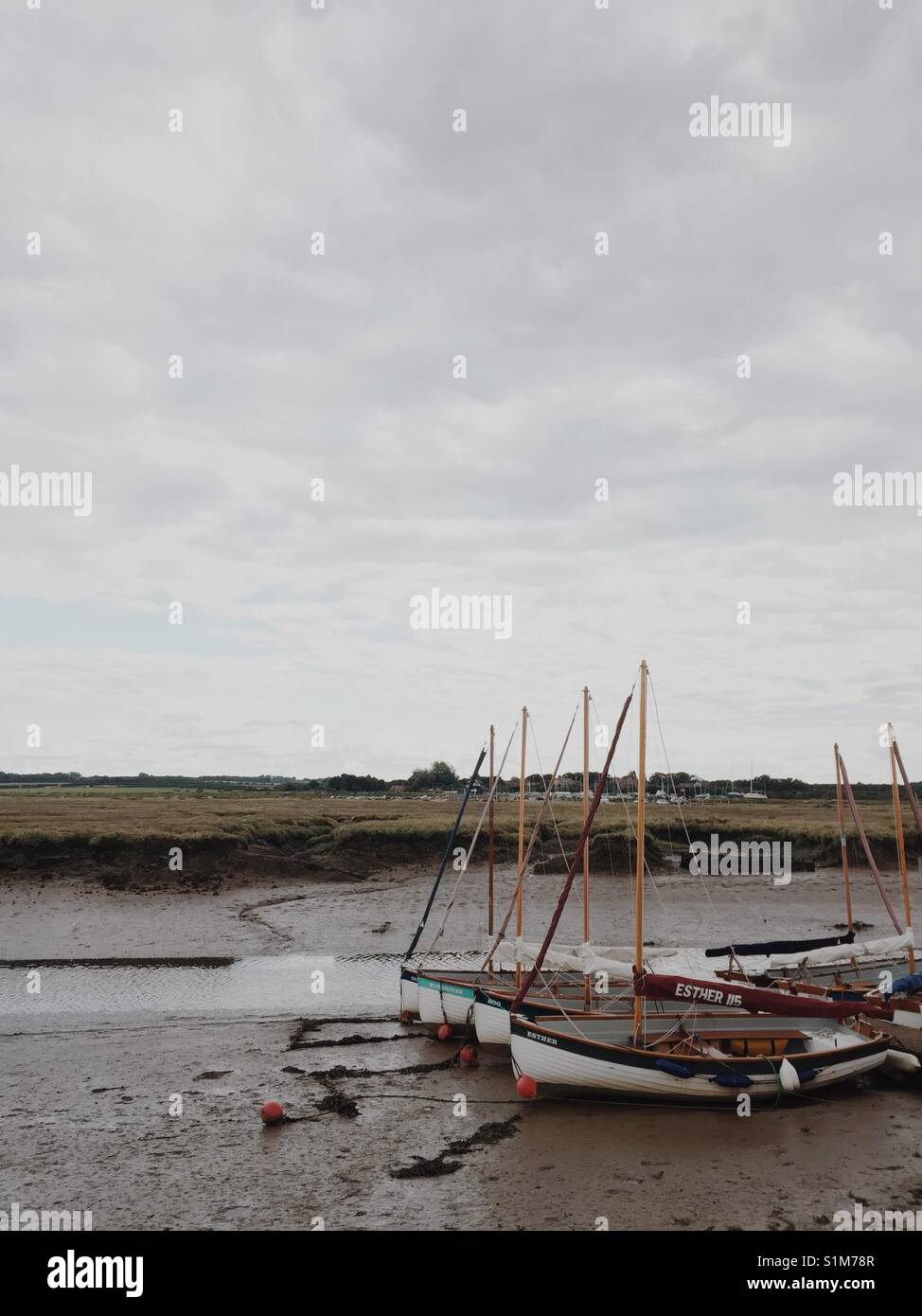 Wooden sailing Boats from boat school lined up at Morston Quay, North Norfolk, UK - Smartphone Captured Stock Image