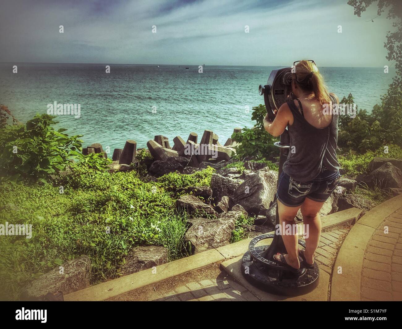 Woman looking through viewer at Lake Erie boats - Smartphone Captured Stock Image
