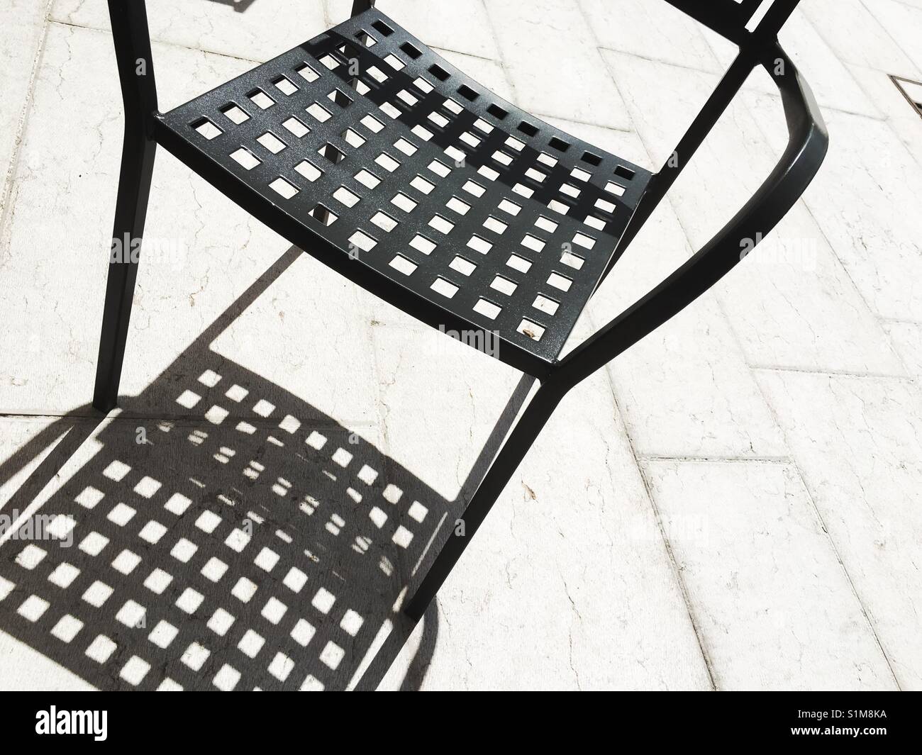 Silhouette of metal garden chair on a sunny day - Smartphone Captured Stock Image